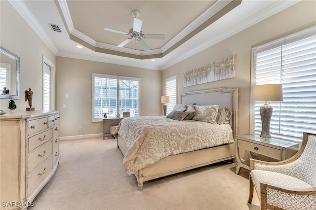 bedroom with light carpet, ceiling fan, a tray ceiling, and ornamental molding