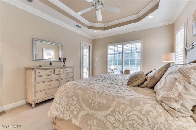 carpeted bedroom featuring ceiling fan, crown molding, and a tray ceiling