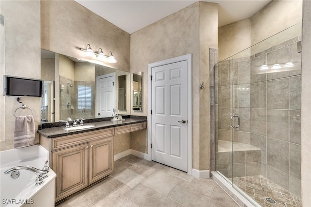 bathroom featuring vanity and independent shower and bath