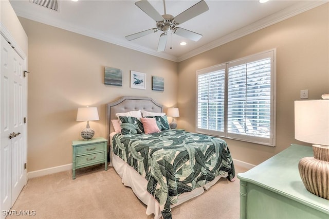 bedroom with light colored carpet, ceiling fan, crown molding, and a closet