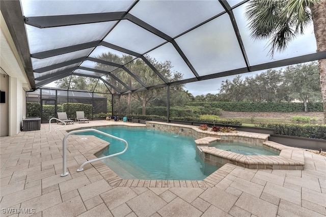 view of pool featuring a patio area, glass enclosure, and an in ground hot tub