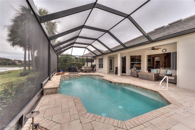 view of swimming pool with a patio area, outdoor lounge area, glass enclosure, ceiling fan, and pool water feature