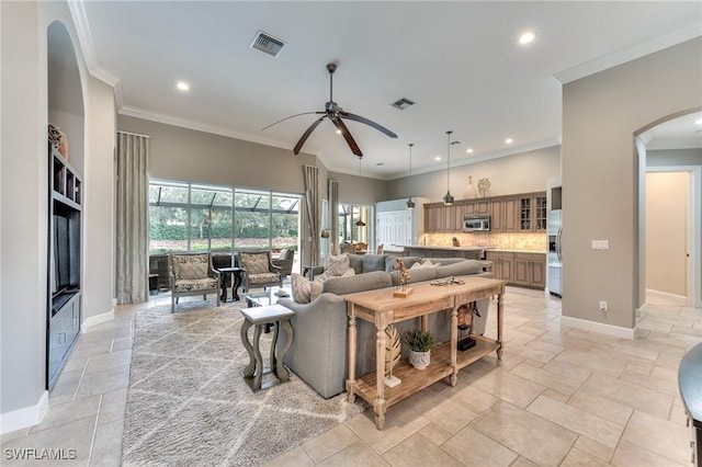 living room with ornamental molding and ceiling fan