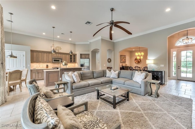 living room featuring ceiling fan with notable chandelier and crown molding