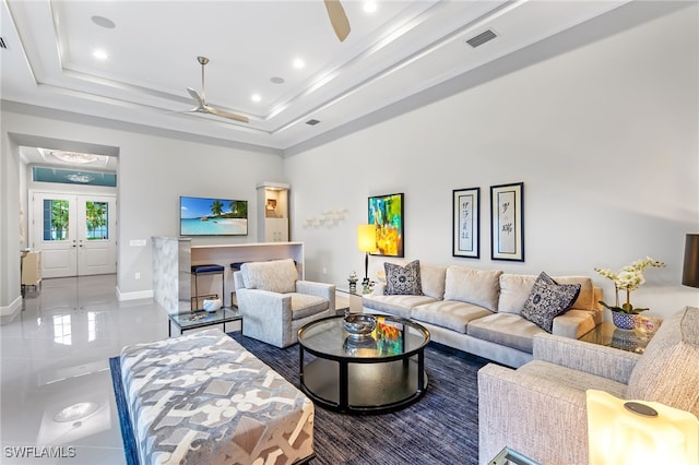 living room featuring french doors, ceiling fan, tile patterned flooring, and a raised ceiling