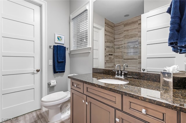 bathroom with toilet, vanity, a shower, and hardwood / wood-style flooring