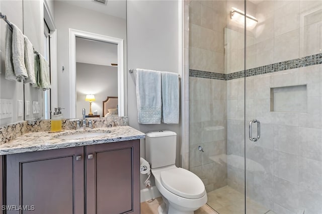 bathroom featuring toilet, a shower with door, and vanity