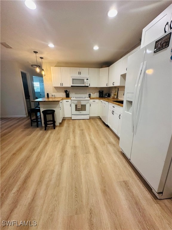 kitchen with white appliances, wooden counters, decorative light fixtures, white cabinetry, and light wood-type flooring