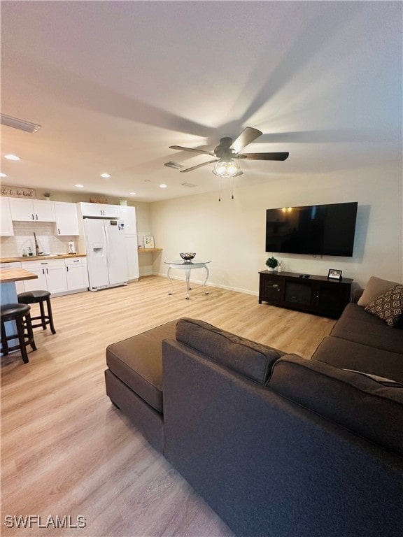 living room featuring light wood-type flooring and ceiling fan