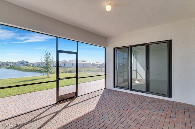 unfurnished sunroom with a water view