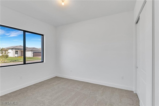 unfurnished room featuring light carpet