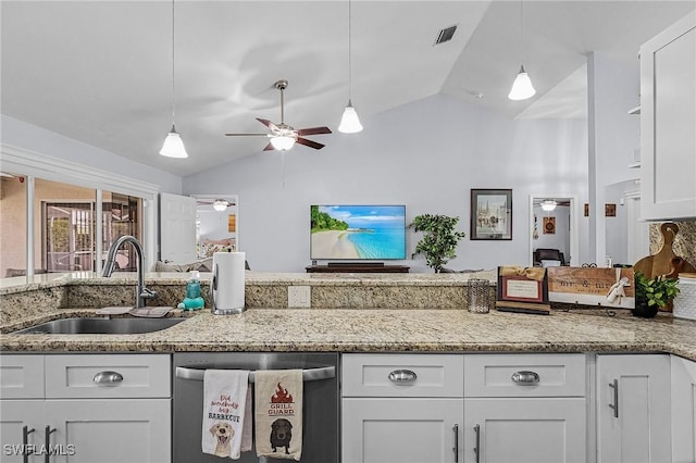 kitchen featuring lofted ceiling, sink, light stone countertops, white cabinets, and stainless steel dishwasher