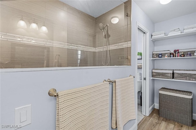 bathroom featuring hardwood / wood-style floors and tiled shower