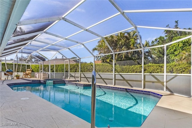 view of pool with a patio and glass enclosure