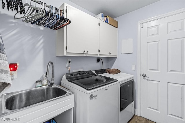 laundry area with dark hardwood / wood-style flooring, sink, cabinets, and washing machine and clothes dryer