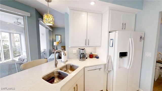 kitchen featuring pendant lighting, white appliances, white cabinetry, tasteful backsplash, and sink