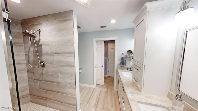 2135 Arielle Dr Unit 2407, Naples, FL 34109 - bathroom with double vanity, a tile shower, recessed lighting, and wood finished floors