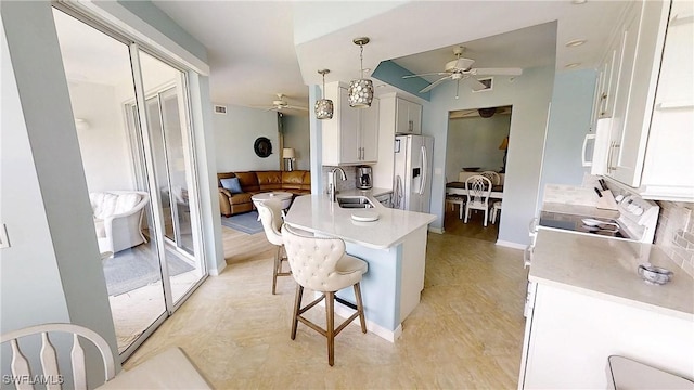 2135 Arielle Dr Unit 2407, Naples, FL 34109 - kitchen featuring ceiling fan, white appliances, a breakfast bar, light countertops, and tasteful backsplash