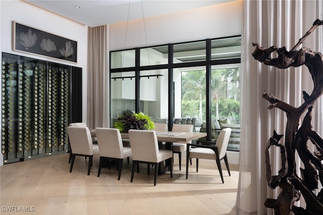 dining room featuring floor to ceiling windows and light hardwood / wood-style flooring