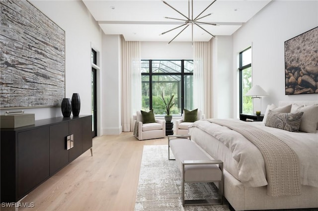 bedroom with a chandelier and light hardwood / wood-style flooring