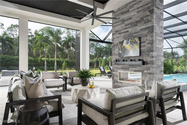 sunroom / solarium featuring ceiling fan and an outdoor stone fireplace