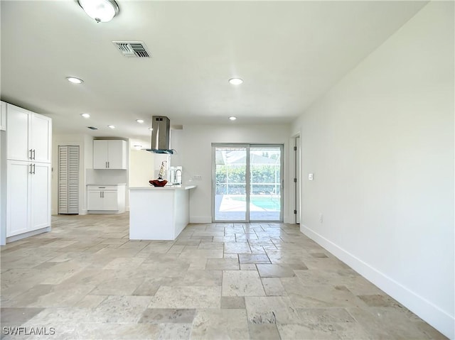 kitchen featuring white cabinetry and island range hood