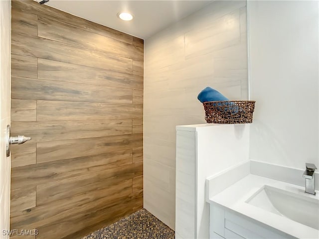 bathroom featuring a tile shower and sink