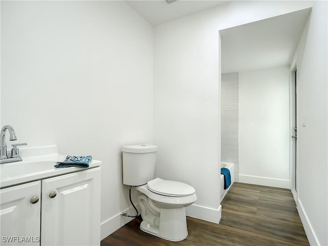 bathroom with wood-type flooring, toilet, and vanity