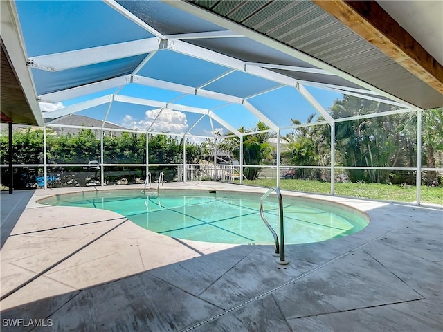 view of pool with a patio area and glass enclosure