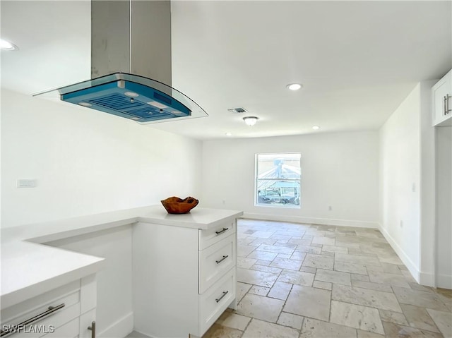 interior space with white cabinets and island range hood