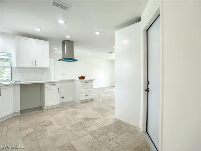 kitchen featuring white cabinetry and island range hood