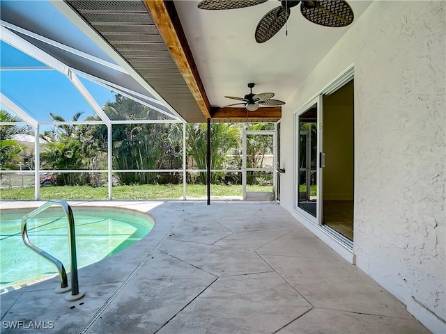 view of swimming pool with ceiling fan, a patio, and glass enclosure