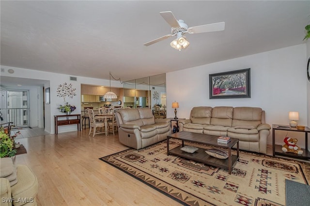 living room with ceiling fan and light hardwood / wood-style flooring