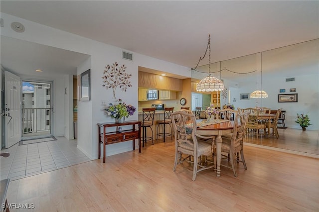 dining space with light hardwood / wood-style floors