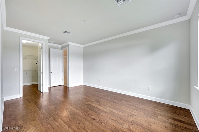 unfurnished room featuring dark wood-type flooring and crown molding