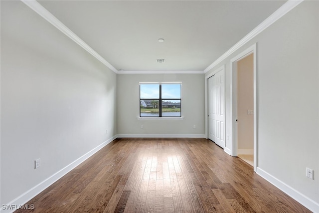 spare room featuring hardwood / wood-style flooring and ornamental molding