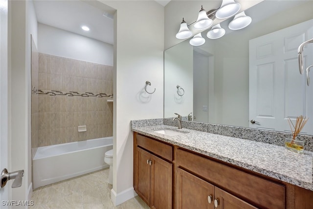 full bathroom featuring tiled shower / bath, vanity, and toilet