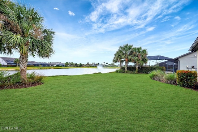 view of yard featuring glass enclosure and a water view