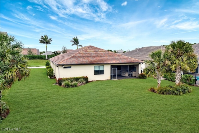 back of house with a yard and a sunroom