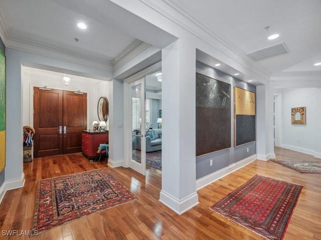 entrance foyer featuring crown molding and hardwood / wood-style flooring