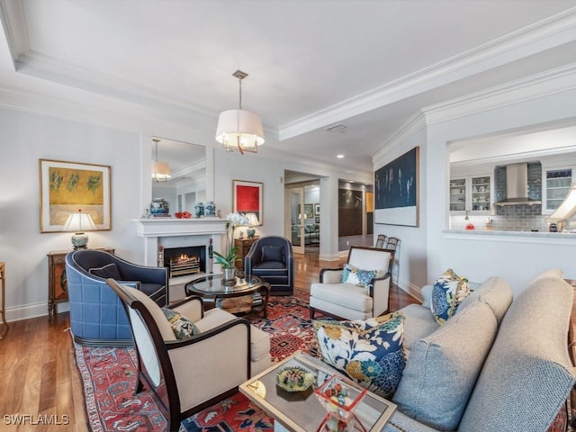 living room featuring a tray ceiling, crown molding, and hardwood / wood-style floors