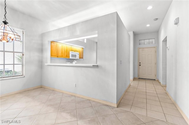 interior space featuring light tile patterned floors and a chandelier