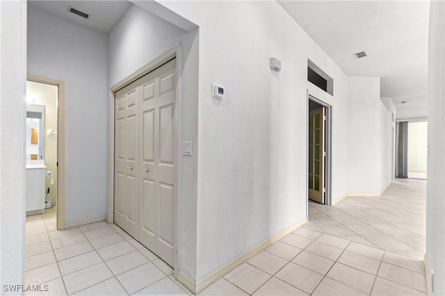 hall featuring light tile patterned floors