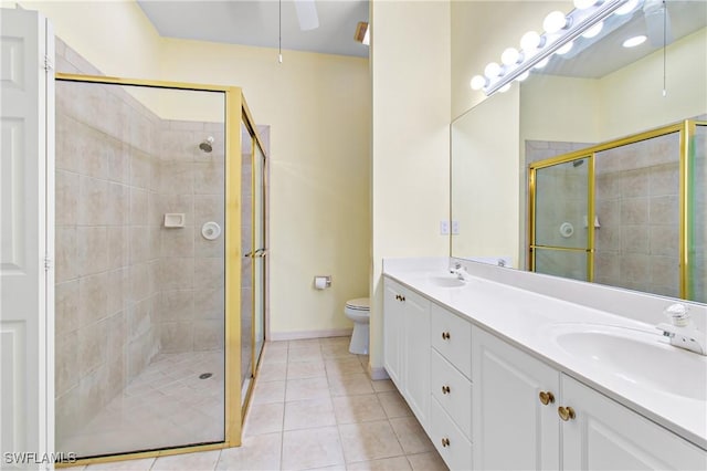 bathroom featuring toilet, vanity, tile patterned flooring, and an enclosed shower