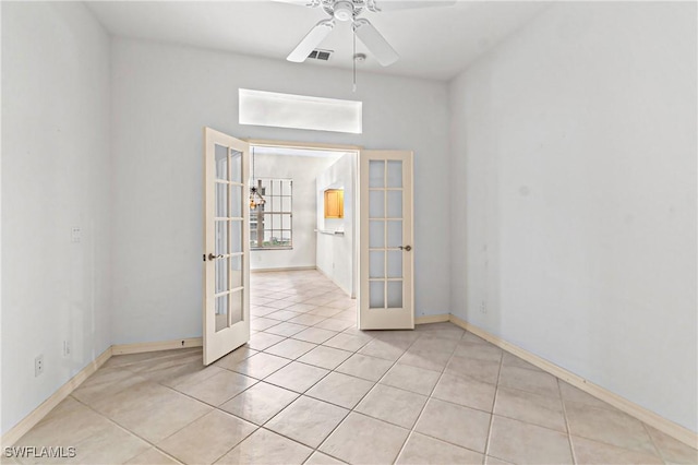 tiled empty room with ceiling fan and french doors