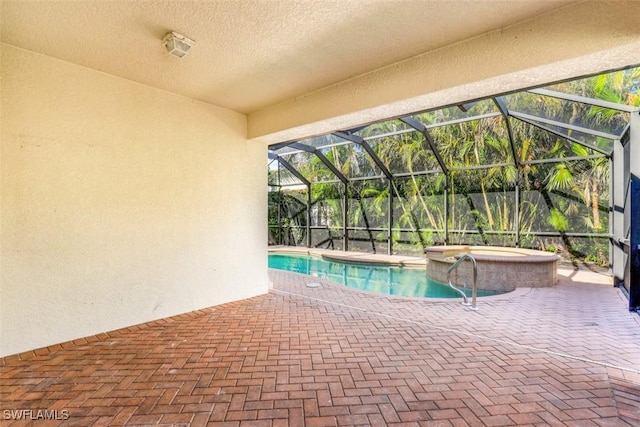 view of pool featuring an in ground hot tub, a patio, and glass enclosure