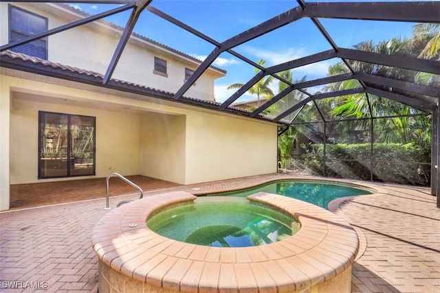 view of swimming pool with a lanai, an in ground hot tub, and a patio