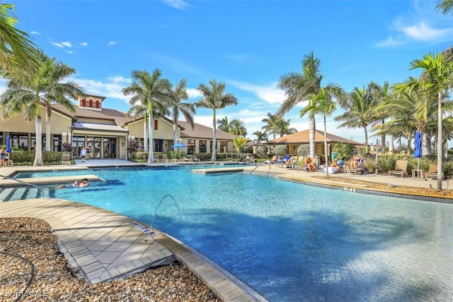 view of swimming pool featuring a hot tub and a patio area