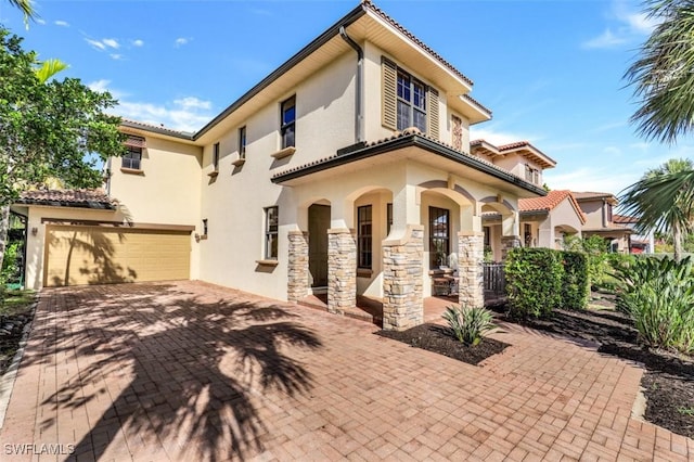 mediterranean / spanish home with covered porch and a garage