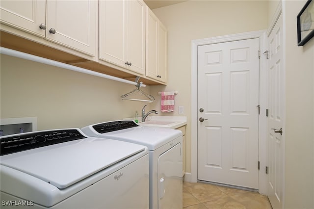 laundry room featuring cabinets, sink, light tile patterned floors, and washer and dryer